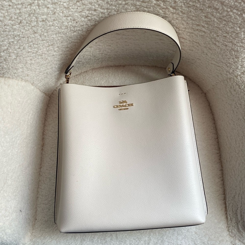 Coach white town bucket bag with gold accents.